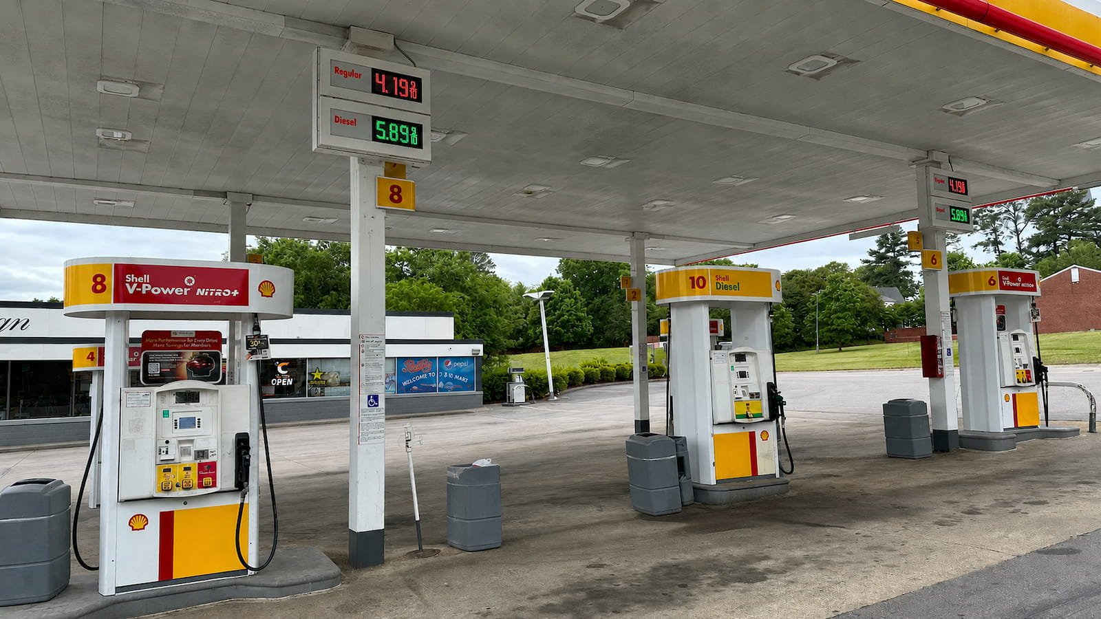 Dirty gas station concrete and fuel pump area before commercial pressure washing in Ennis TX