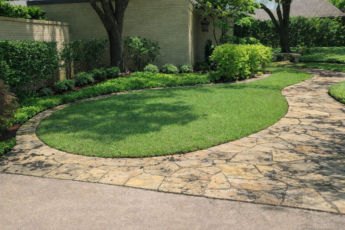 Natural flagstone walkway in Corsicana TX covered in heavy black mold and slippery organic buildup before soft washing