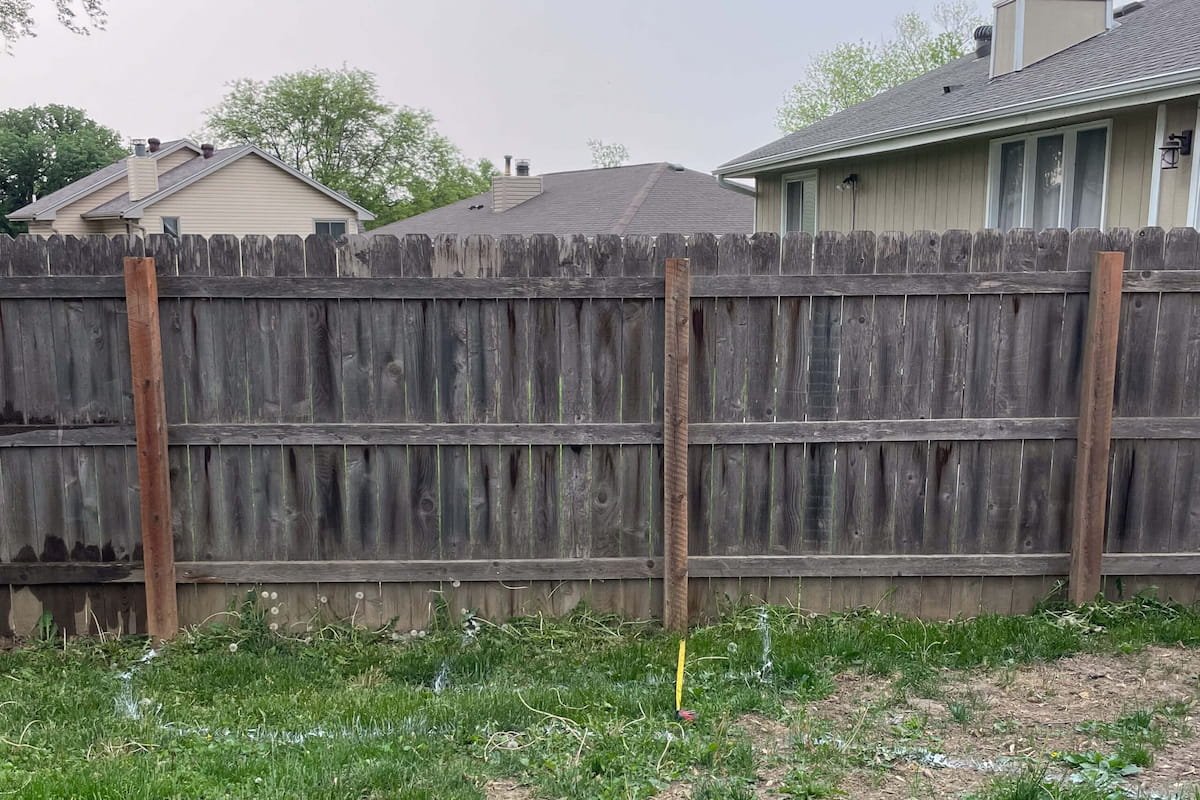 Weathered wood privacy fence before cleaning and restoration in Ennis, TX