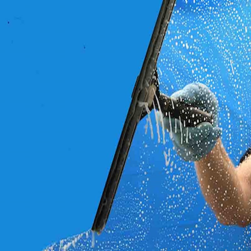 Traditional squeegee pulling soapy water off a clear exterior glass window.